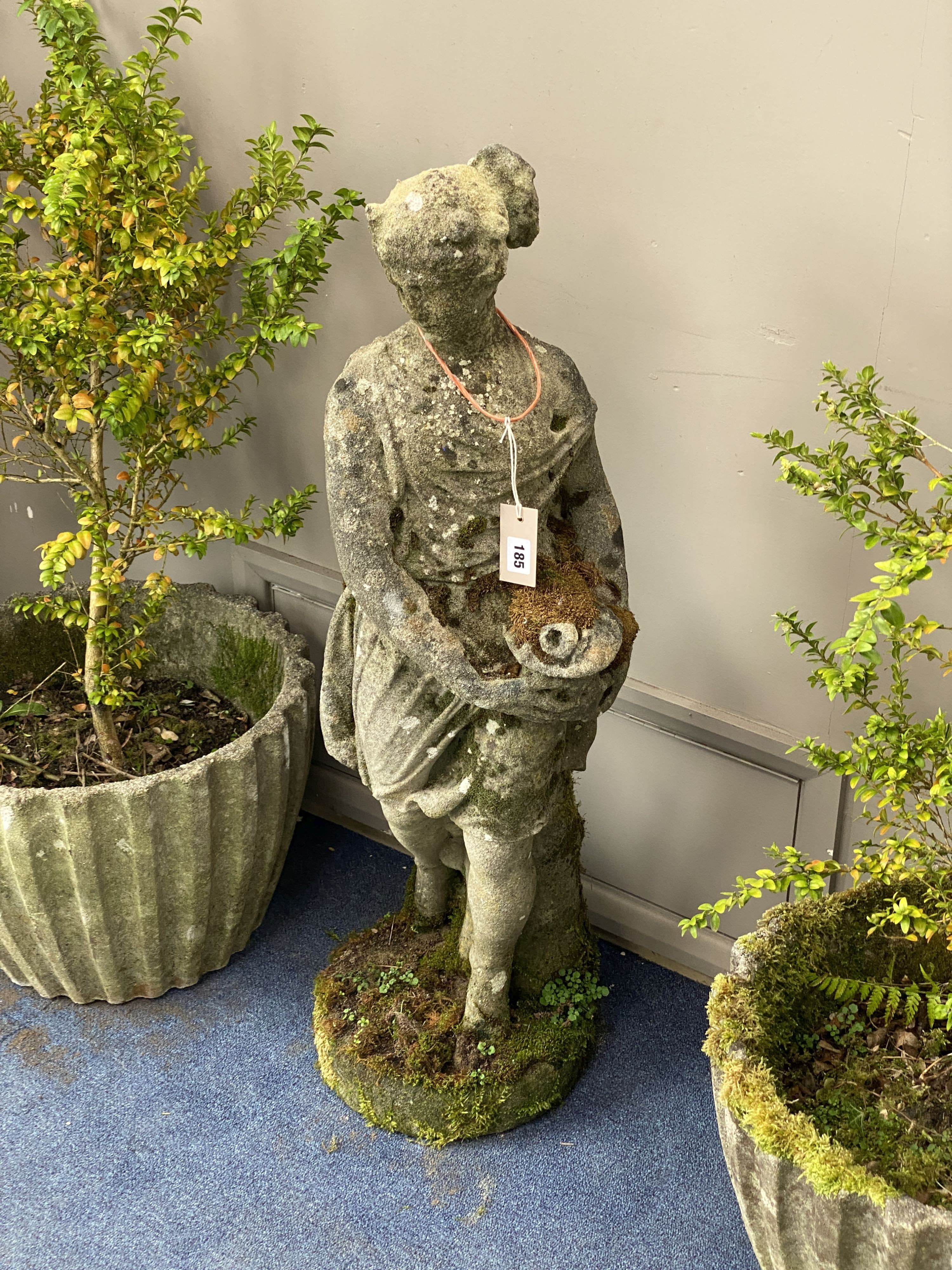 A reconstituted stone figure of a girl holding a basket of flowers, height 97cm